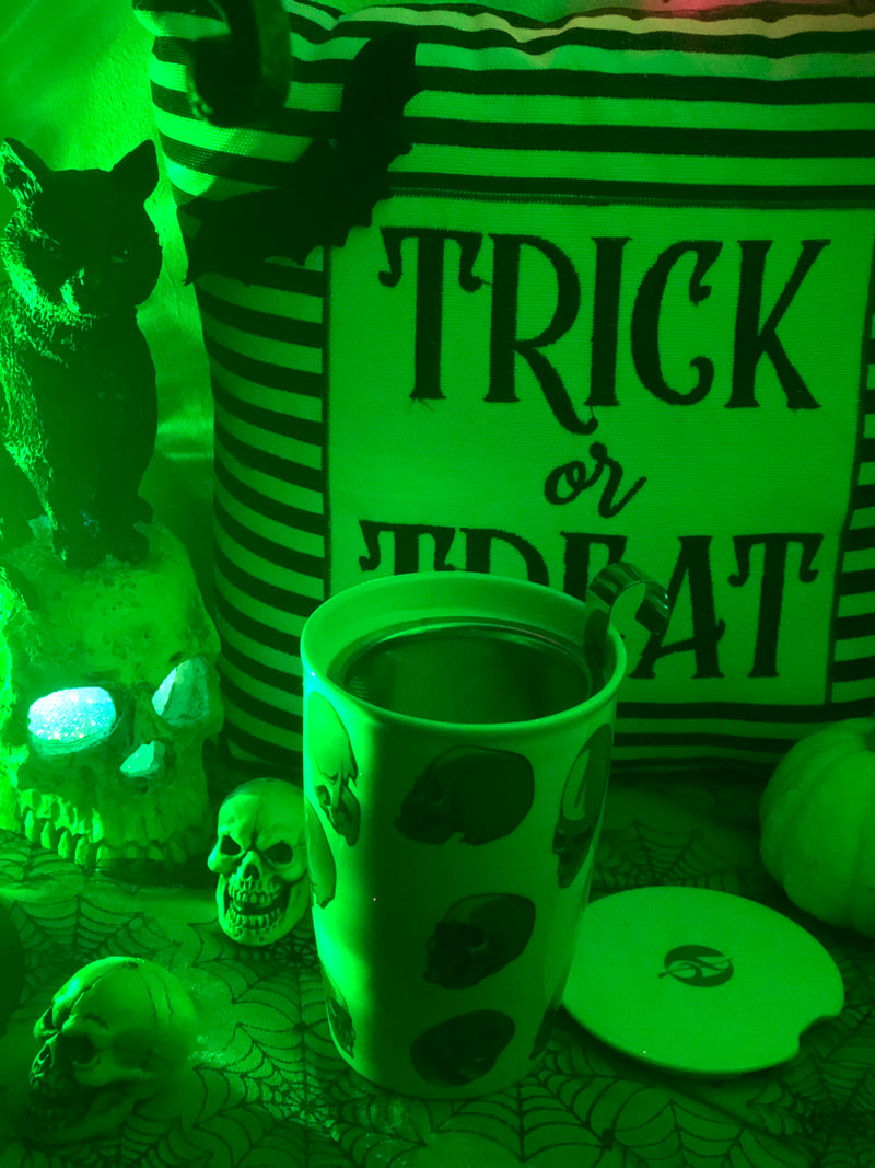 Halloween shelf with black cat and skull tea cup green lights